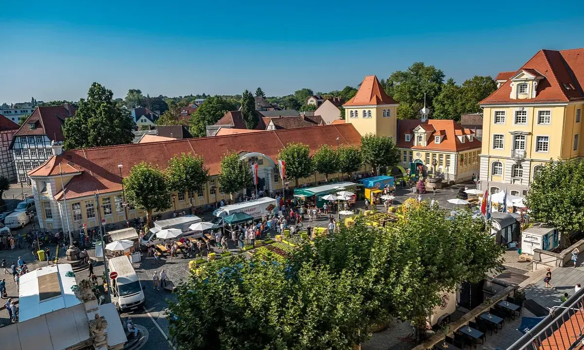 Buntes Treiben auf dem Marktplatz der Herford Innenstadt. Stände, Menschen und Sonnenschein beleben das Bild.