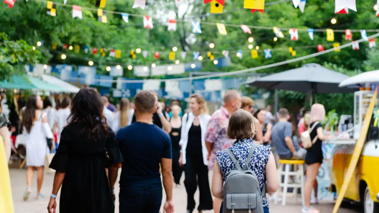 Bunte Flaggen schmücken die Havixbeck Veranstaltungen. Menschen schlendern über einen belebten Markt mit Ständen und Essen.