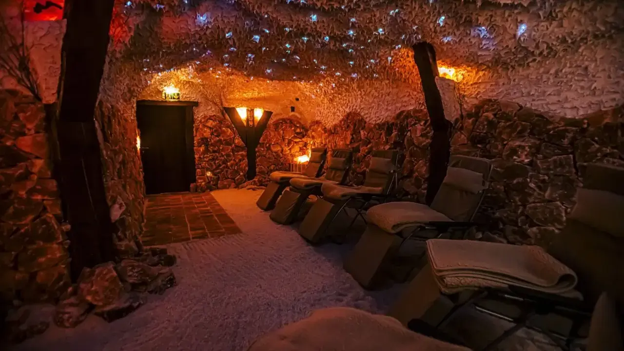 Entspannende Liegestühle in einer **Salzgrotte Paderborn**. Die Wände sind mit Salzsteinen verkleidet, die Decke funkelt mit kleinen Lichtern.