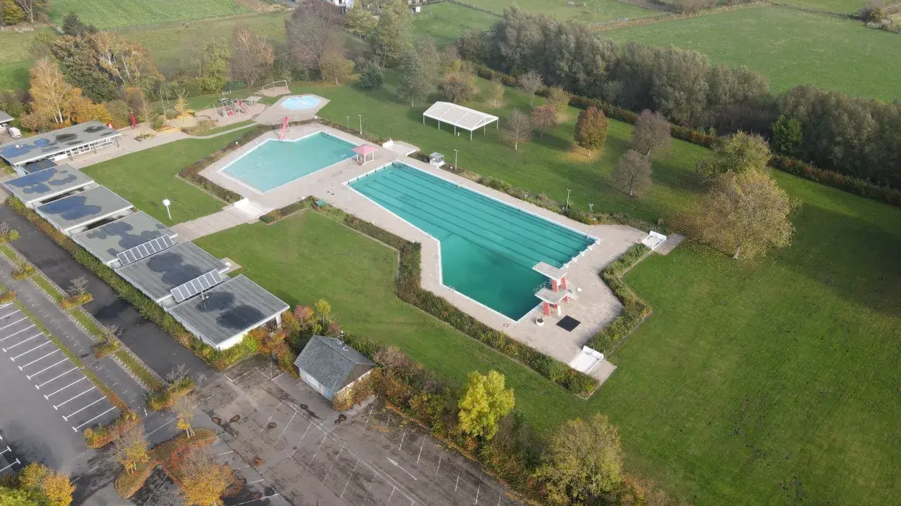 Luftaufnahme des Freibad Gehlenbeck mit Schwimmbecken, Sprungturm und Spielplatz.
