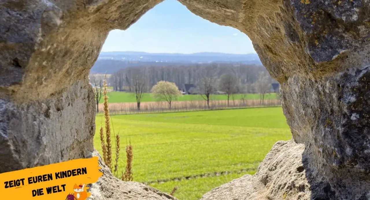Blick durch eine Felsöffnung auf grüne Felder und Bäume. Perfekt für Ausflugsziele OWL mit Kindern, um die Natur zu entdecken.