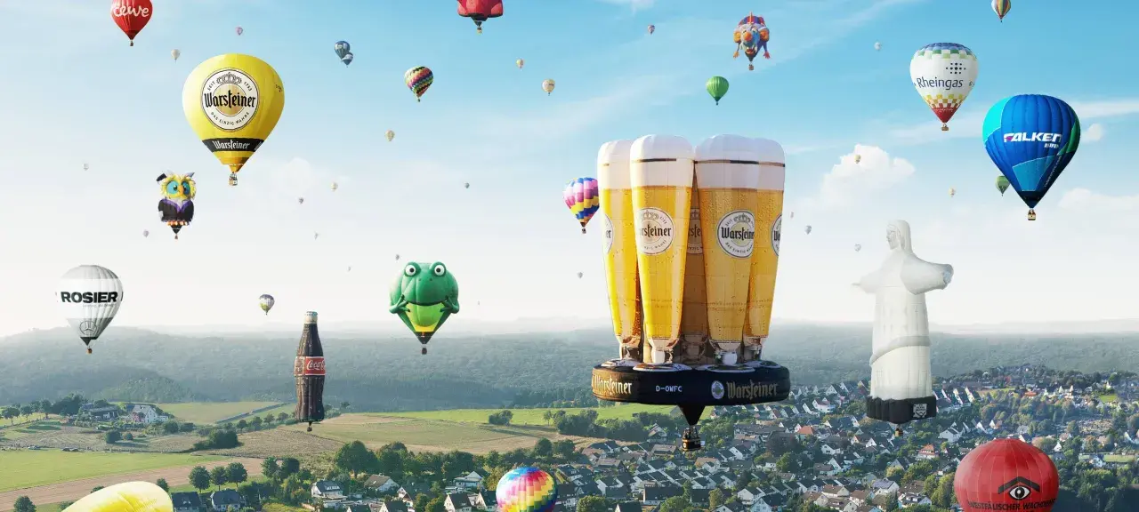 Bunte Ballons, darunter ein riesiges Bierglas von Warsteiner, steigen bei der Warsteiner Montgolfiade in den Himmel.