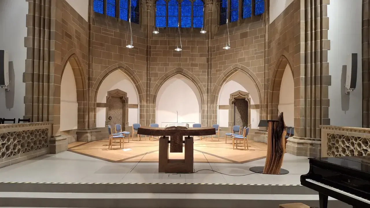 Innenraum der Christuskirche Detmold mit Altar, Stühlen und einem Flügel.
