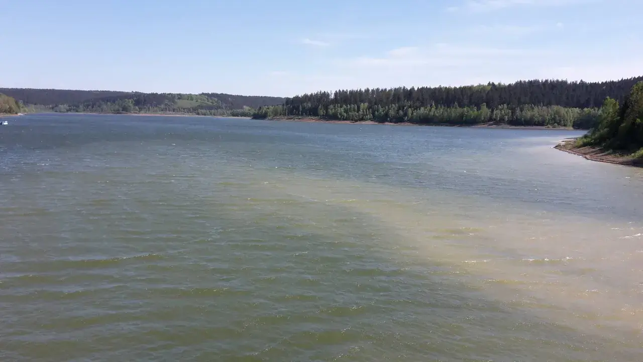 Blick über die Aabachtalsperre mit bewaldeten Ufern. Der Rundweg lädt zu Spaziergängen ein.