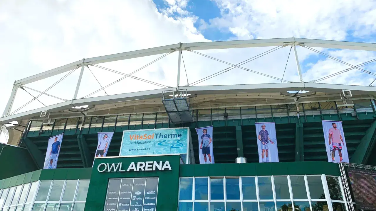 Die OWL ARENA ist bereit für das terra wortmann open. Banner mit Tennisspielern zieren die Fassade.