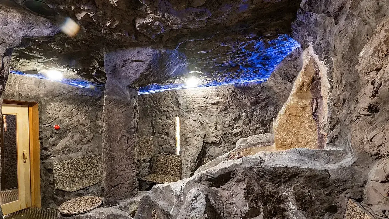 Entspannende Höhle mit Sitzbänken und blauem Licht, ein Ort zum Wohlfühlen im spa Bielefeld.