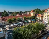 Buntes Treiben auf dem Marktplatz der Herford Innenstadt. Stände, Menschen und Sonnenschein beleben das Bild.
