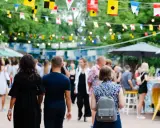 Bunte Flaggen schmücken die Havixbeck Veranstaltungen. Menschen schlendern über einen belebten Markt mit Ständen und Essen.