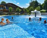 Entspannte Menschen genießen das Schwimmbad eines Kurortes in NRW. Ein Wasserspiel sorgt für Erfrischung.