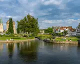 Entspannte Menschen genießen die Sonne am Flussufer in Paderborn. Ein schöner Ort für Paderborn Geheimtipps.