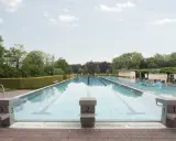 Leeres Freibad Barntrup mit Bahnen und Sprungblöcken. Ein blauer Wal schwimmt im Wasser.