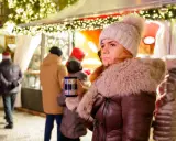 Frau mit Becher auf dem **Weihnachtsmarkt Nottuln**, umgeben von Lichtern und Menschen.