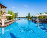 Entspannung pur im Solebad NRW: Ein luxuriöser Pool mit Blick auf den See, umgeben von Bambus und Liegestühlen.