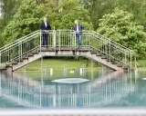 Zwei Männer stehen auf einer Brücke über dem Wasser des Freibad Porta Westfalica.