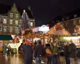 Menschen genießen den festlich beleuchteten weihnachtsmarkt bocholt mit einem großen Weihnachtsbaum und einem Rentier aus Lichtern.