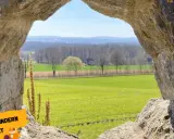 Blick durch eine Felsöffnung auf grüne Felder und Bäume. Perfekt für Ausflugsziele OWL mit Kindern, um die Natur zu entdecken.