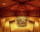 Gemütliche Sauna mit Steinofen und Holzbänken in der Therme Herford. Entspannung pur in rustikalem Ambiente.