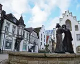 Skulpturen auf dem Markt Brakel vor Fachwerkhäusern und einem weißen Giebelhaus.