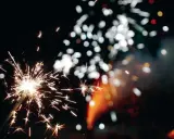 Funkelnde Wunderkerzen und verschwommene Lichter am Silvesterhimmel in Minden.