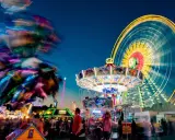 Buntes Treiben am Familientag Kirmes mit Karussells, Riesenrad und Lichtern.