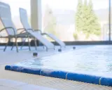 Entspannen Sie sich am Pool der Olsberg Therme. Liegestühle stehen bereit, während das Wasser sanft plätschert.