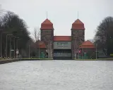 Die Schachtschleuse Minden mit ihren markanten Türmen und roten Ziegeldächern ragt über das ruhige Wasser.