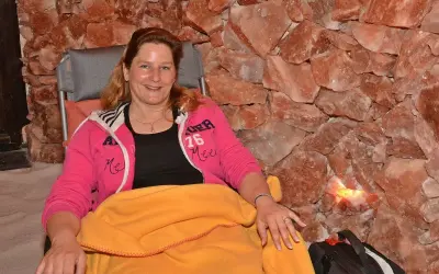 Entspannte Frau in der Bad Salzuflen Salzgrotte, umgeben von rosa Salzsteinen.