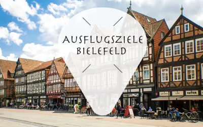 Ein Tag in Bielefeld: Fachwerkhäuser säumen die Straße, Menschen sitzen in Cafés.
