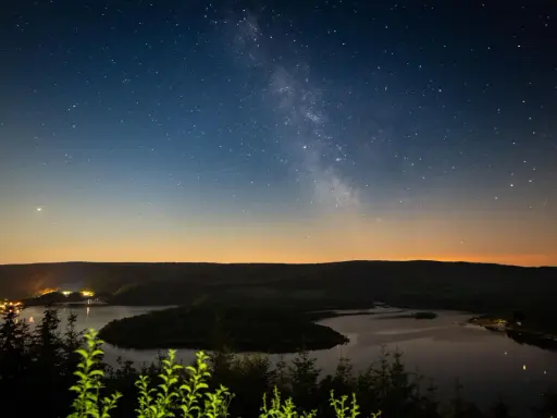 Sternenhimmel über einem See in NRW. Ein perfekter Ort zum Sterne gucken.