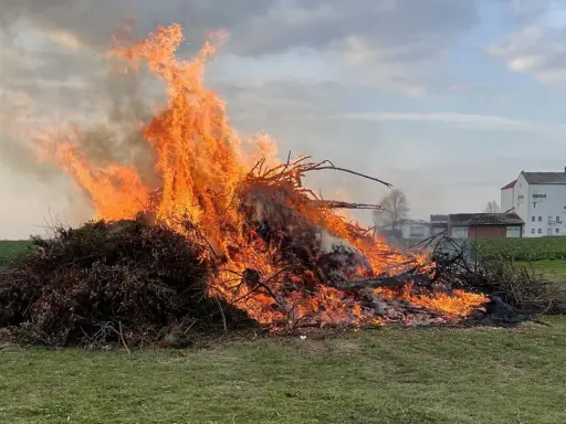 Großer Osterfeuer-Brauch: Ein Mann beobachtet die Flammen. Typische Oster Veranstaltungen.