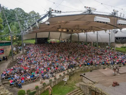 Großes Freilichttheater mit vielen Zuschauern bei Tecklenburg Veranstaltungen. Ein Schauspiel wird auf der Bühne aufgeführt.