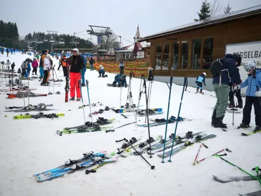 Skifahrer warten auf die Gondelbahn. Entdecke die **Winterberg Geheimtipps** für deinen nächsten Skiurlaub!