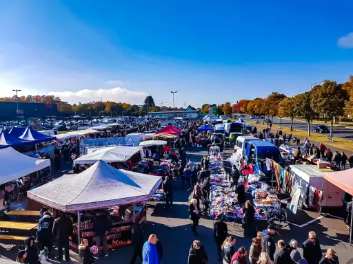 Buntes Treiben auf dem flohmarkt paderborn. Viele Stände mit Kleidung und Trödel unter blauem Himmel.