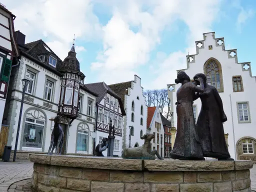 Skulpturen auf dem Markt Brakel vor Fachwerkhäusern und einem weißen Giebelhaus.