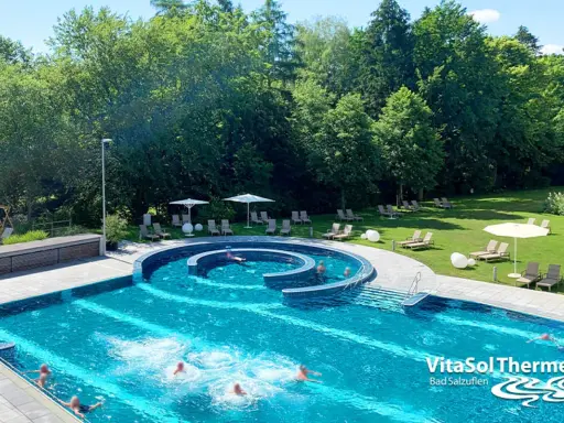 Erfrischendes Schwimmbad mit Liegen und Sonnenschirmen im Außenbereich der VitaSol Therme Bad Salzuflen.