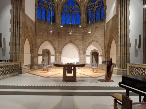 Innenraum der Christuskirche Detmold mit Altar, Stühlen und einem Flügel.
