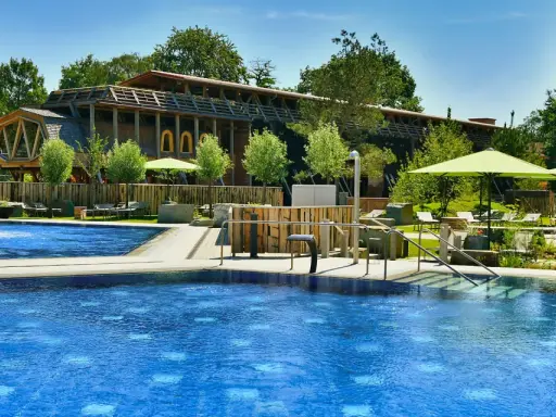 Entspannter Tag am Pool in Bad Sassendorf. Blaue Wasserflächen, Liegen unter Sonnenschirmen und ein Brunnen laden zum Verweilen ein.
