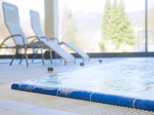 Entspannen Sie sich am Pool der Olsberg Therme. Liegestühle stehen bereit, während das Wasser sanft plätschert.