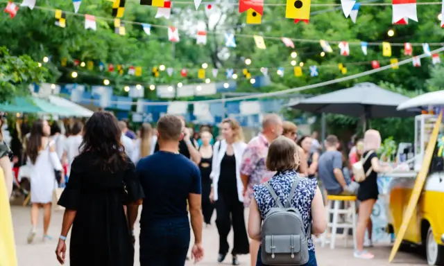 Bunte Flaggen schmücken die Havixbeck Veranstaltungen. Menschen schlendern über einen belebten Markt mit Ständen und Essen.