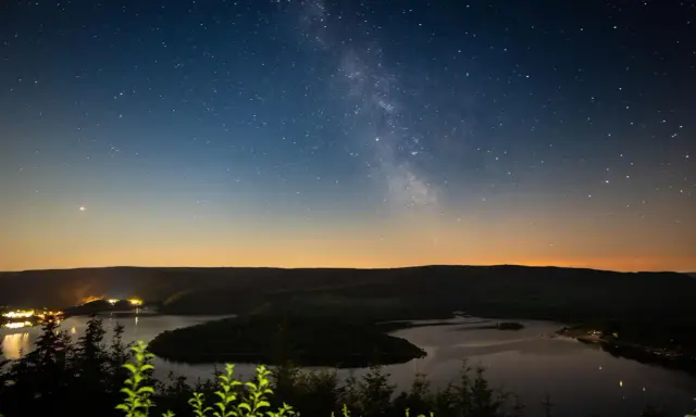 Sternenhimmel über einem See in NRW. Ein perfekter Ort zum Sterne gucken.
