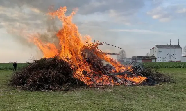 Großer Osterfeuer-Brauch: Ein Mann beobachtet die Flammen. Typische Oster Veranstaltungen.