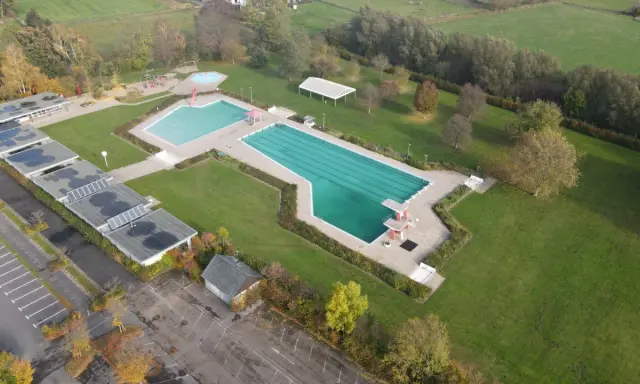 Luftaufnahme des Freibad Gehlenbeck mit Schwimmbecken, Sprungturm und Spielplatz.