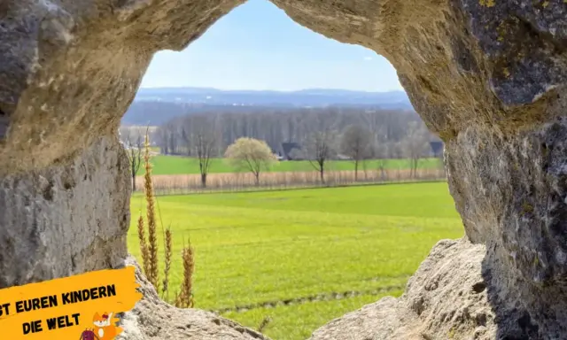 Blick durch eine Felsöffnung auf grüne Felder und Bäume. Perfekt für Ausflugsziele OWL mit Kindern, um die Natur zu entdecken.