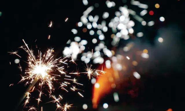 Funkelnde Wunderkerzen und verschwommene Lichter am Silvesterhimmel in Minden.