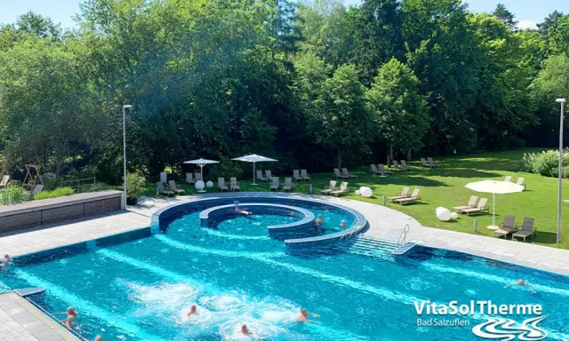 Erfrischendes Schwimmbad mit Liegen und Sonnenschirmen im Außenbereich der VitaSol Therme Bad Salzuflen.