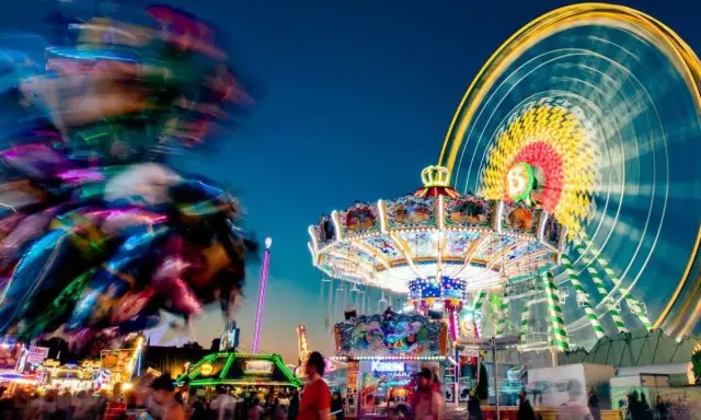 Buntes Treiben am Familientag Kirmes mit Karussells, Riesenrad und Lichtern.