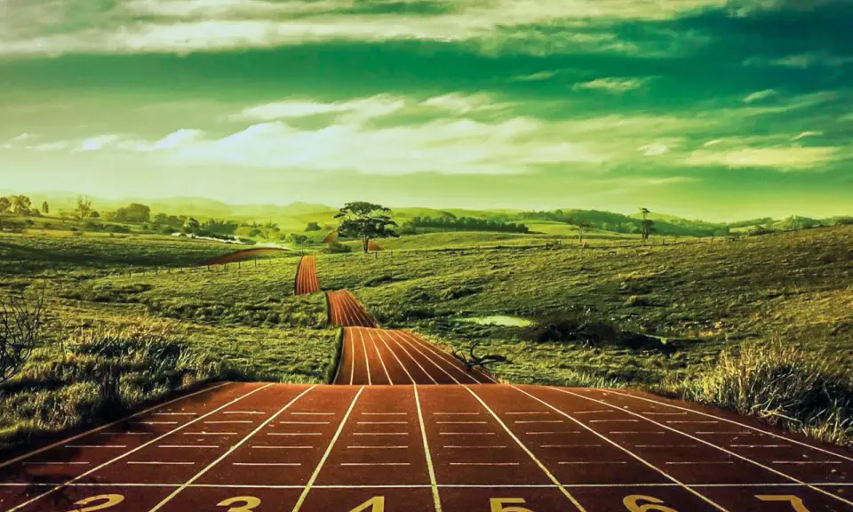 Eine Laufbahn schlängelt sich durch grüne Hügel, bereit für den Bentfelder Abendlauf.