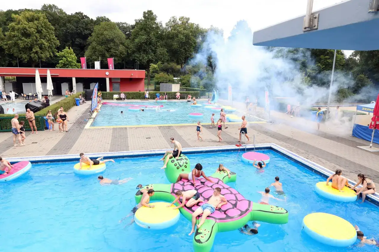 Sommerlicher Badespa&szlig; im Freibad NRW mit aufblasbaren Tieren und viel Rauch.