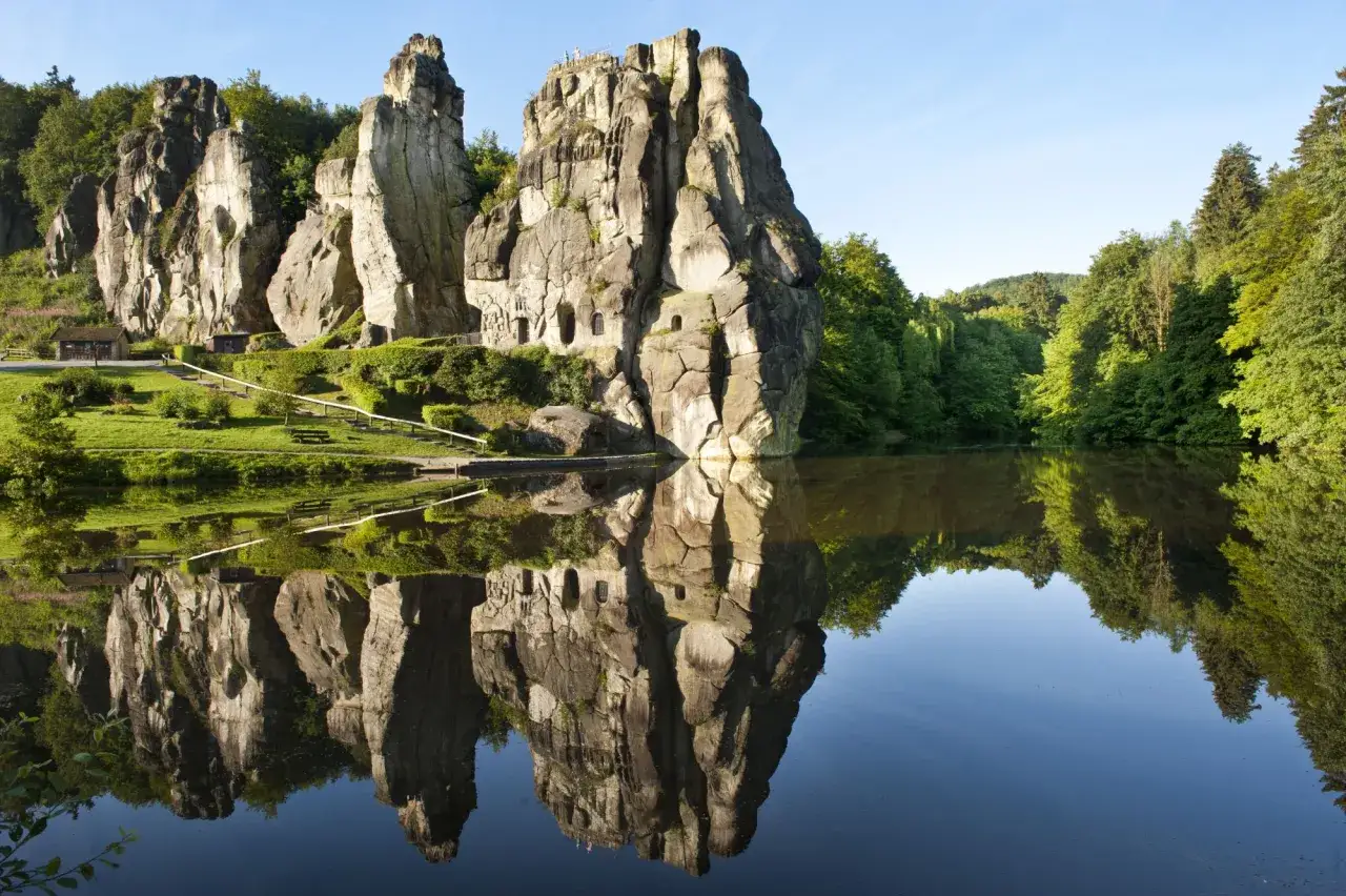 Felsformationen spiegeln sich in einem ruhigen See. Ein idealer Ort f&uuml;r entspannte rundwanderwege im Teutoburger Wald.