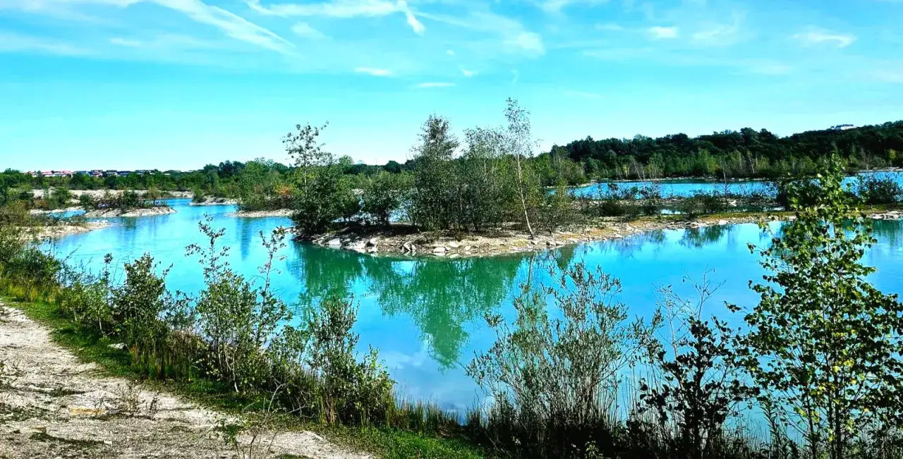 Eine traumhafte blaue Lagune mit grünen Bäumen und einem hellblauen Himmel.